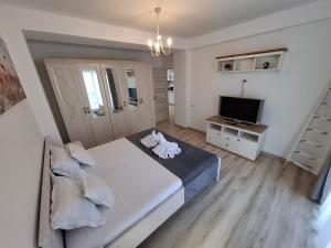 ein Schlafzimmer mit einem großen Bett und einem Fernseher in der Unterkunft SAB Apartament Mamaia Nord-Navodari in Mamaia Nord – Năvodari
