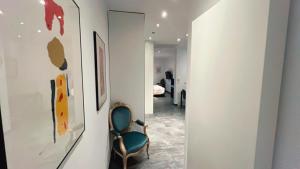 a hallway with a green chair in a room at Domus Hotel in Luxembourg