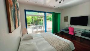 a bedroom with a bed and a desk and a television at Domus Hotel in Luxembourg