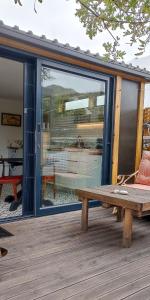 una panca di legno seduta su un ponte con finestra di The Bungalow a Città del Capo