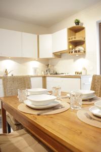 - une table en bois avec des assiettes et des verres dans la cuisine dans l'établissement Sunny Stay & Chill, à Bruxelles