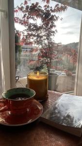 una candela seduta su un tavolo di fronte a una finestra di Brasov Loft a Braşov