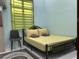 a bed with two pillows on it in a room at Homestay Adilah D in Selising