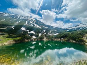 a body of water with snow covered mountains at Na planina in Razlog
