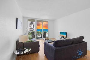 a living room with a couch and a television at Tides beautiful ocean view condo-promotions in Hollywood
