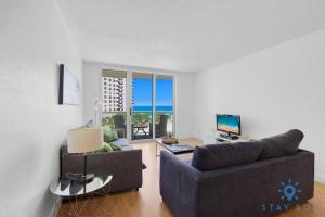 a living room with a couch and a television at Tides beautiful ocean view condo-promotions in Hollywood +29 photos