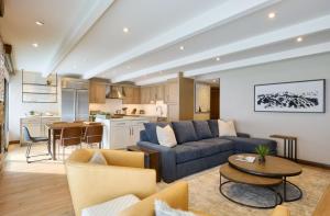 Una sala de estar con un sofá azul y una cocina. en Vail - Lionshead Condominiums 2 Bedroom Condo, en Vail