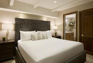 Un dormitorio con una gran cama blanca y un espejo. en Vail - Lionshead Condominiums 2 Bedroom Condo, en Vail 12 fotos más