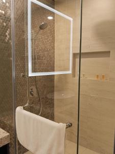 a shower with a glass door and a towel at My Residence Villa Star Klcc in Kuala Lumpur