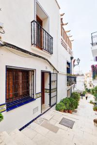 un edificio blanco con puertas y ventanas negras en Gema histórica en Santa Cruz Doble Terraza Vistas, en Alicante