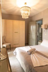 a bedroom with a large bed and a chandelier at Silot apartment 1 in Nea Fokea