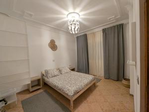 艾西拉City Escape Assilah 2的一间带床和吊灯的卧室