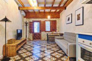 Una sala de estar con un sofá y un televisor. en Gema histórica en Santa Cruz Doble Terraza Vistas, en Alicante