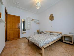 艾西拉City Escape Assilah 2的一间白色的卧室,配有床和木门