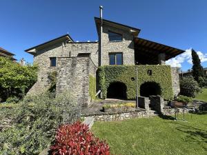 an old stone house with ivy on the side of it at Villa Delia 16p 2 Pools BBQ by VILLASRETREATS in Talavorno