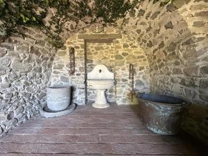 a stone bathroom with a toilet and a tub at Villa Delia 16p 2 Pools BBQ by VILLASRETREATS in Talavorno