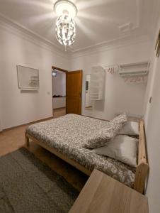 艾西拉City Escape Assilah 2的一间带床和吊灯的卧室 更多7张照片