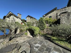 an old stone building with trees and a stone walkway at Villa Delia 16p 2 Pools BBQ by VILLASRETREATS in Talavorno