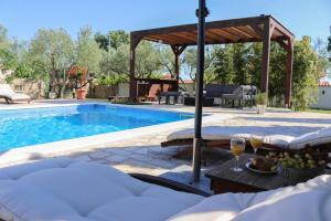 a swimming pool with a table and glasses of wine at Villa Marija ZadarVillas in Poličnik