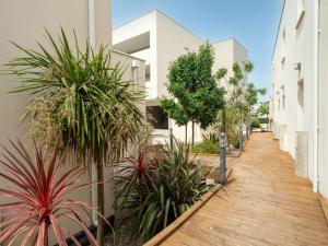 a walkway between two buildings with palm trees at La Dune N 12 - Villa 3P6 in Valras-Plage