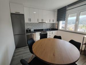 a kitchen with a wooden table and chairs in a kitchen at A Casa Pequena INCostadaMorte in Cee