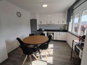 a kitchen with a wooden table and black chairs at A Casa Pequena INCostadaMorte in Cee +24 photos