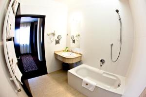 a bathroom with a tub and a sink and a shower at Budapest Airport Hotel Stáció Superior Wellness & Konferencia in Vecsés