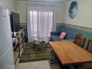 a living room with a blue couch and a table at Heart of Modbury in Modbury