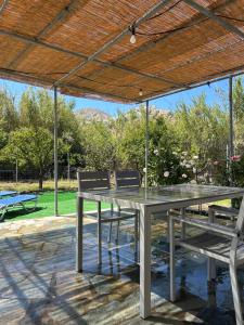 a table and two chairs under a wooden roof at Theros house in Livadion
