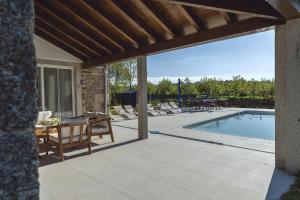 a patio with a table and a swimming pool at Reverence Villas Carballal in Palas de Rei