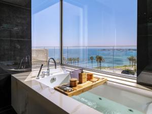 un bagno con un lavandino e una grande finestra di Amavi, MadeForTwo Hotels - Paphos a Paphos