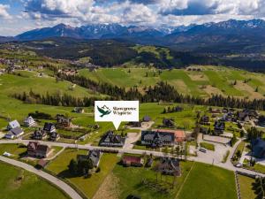 an aerial view of a village with a sign that reads champion properties at Skowyrowe Wzgórze - Pokoje z pięknym widokiem na góry in Gliczarów