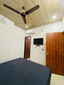 a bedroom with a bed and a ceiling fan at New Hotel Preet Kurukshetra in Kurukshetra +23 photos