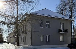 a large house with snow on the ground in front of it at EVIS LTD apartments 5 in Rēzekne