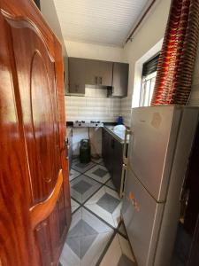 een keuken met een koelkast en een tegelvloer bij Tivana in Kigali