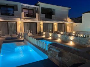 a villa with a swimming pool at night at Skopelos Holidays Hotel & Spa in Skopelos Town