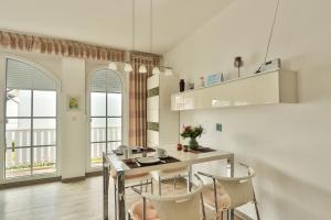 a kitchen with a table and chairs and windows at Eleonore 3 in Ostseebad Nienhagen