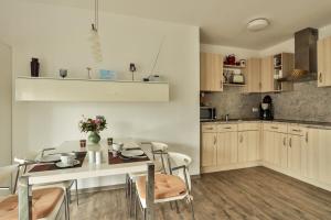 a kitchen and dining room with a table and chairs at Eleonore 3 in Ostseebad Nienhagen +15 photos