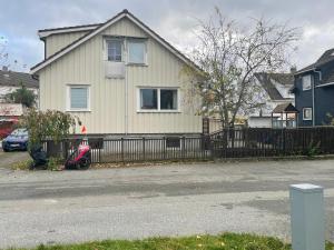 une maison avec un scooter garé devant une clôture dans l'établissement Child friendly basement apartment, à Lii