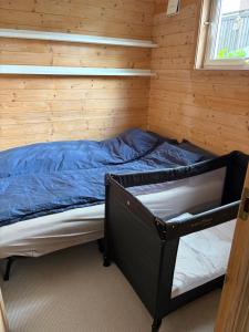 un lit dans une chambre avec un mur en bois dans l'établissement Child friendly basement apartment, à Lii