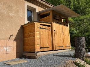 a wooden outbuilding with a door on the side of a house at M'Belles Cabanes in Viala-du-Tarn