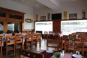 a dining room with tables and chairs in it at Rockwood Resort in Pāonta Sāhib