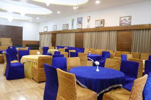 a conference room with blue tables and chairs at Rockwood Resort in Pāonta Sāhib