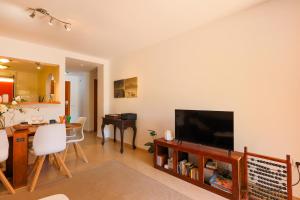 Una sala de estar con televisión y un comedor. en Beach Huisje Mar Menor, en Mar de Cristal