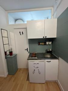 małą kuchnię ze zlewem i oknem w obiekcie Nice 2 Rooms Full Appartement in Paris w Paryżu +7 zdjęć