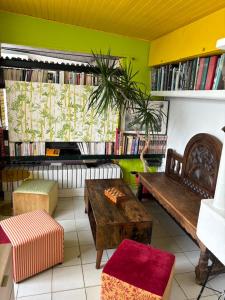 a room with a bench and a table and books at Grand studio vue magique sur Paris in Suresnes