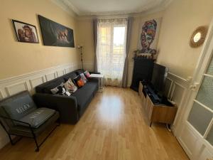 salon z kanapą i telewizorem w obiekcie Nice 2 Rooms Full Appartement in Paris w Paryżu
