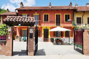 an orange and yellow house with an open gate at Il Casale Del Roero in Canale