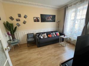 salon z czarną kanapą z poduszkami w obiekcie Nice 2 Rooms Full Appartement in Paris w Paryżu