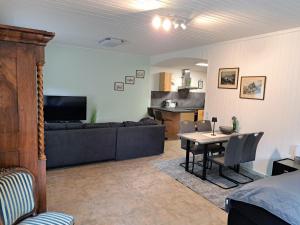 梅尔齐希Schloss Hilbringen Wirtschaftsgebäude的客厅里有一张桌子和一张沙发